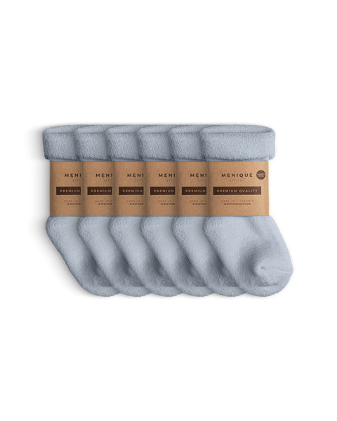 Set of six pairs of light blue sherpa-style children’s socks, bundled together with Menique eco kraft paper wraps reading ‘Premium Quality.