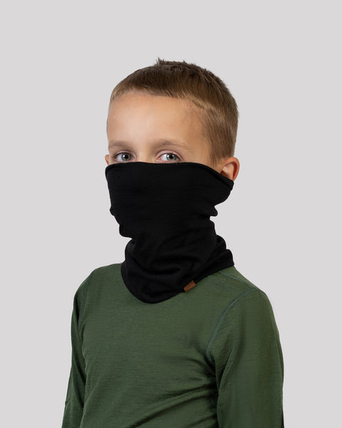 Boy wearing a black Merino wool neck gaiter and green base layer – soft, insulating neck warmer for children.