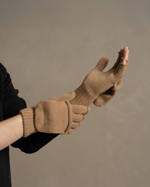 Caramel brown merino wool convertible gloves worn on hands, showing fingerless gloves with fold-over mitten cover.