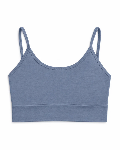 A flat-lay product shot of a women's bralette in a dusty blue color, displayed upright against a pure white background. The bralette features a scoop neckline, thin shoulder straps, and a wide band at the bottom. The fabric has a smooth texture.