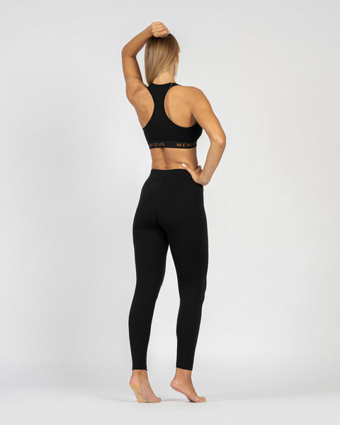 The menique women's merino wool sport bra in 160gsm and leggings in 250gsm fabric, black color, back view.