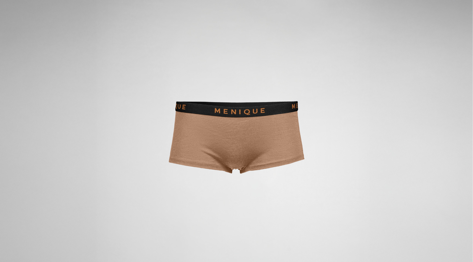 A pair of women's taupe-colored boyshort underwear is displayed flat against a gray background. They feature a contrasting black waistband with the word "MENIQUE" written in copper lettering.
