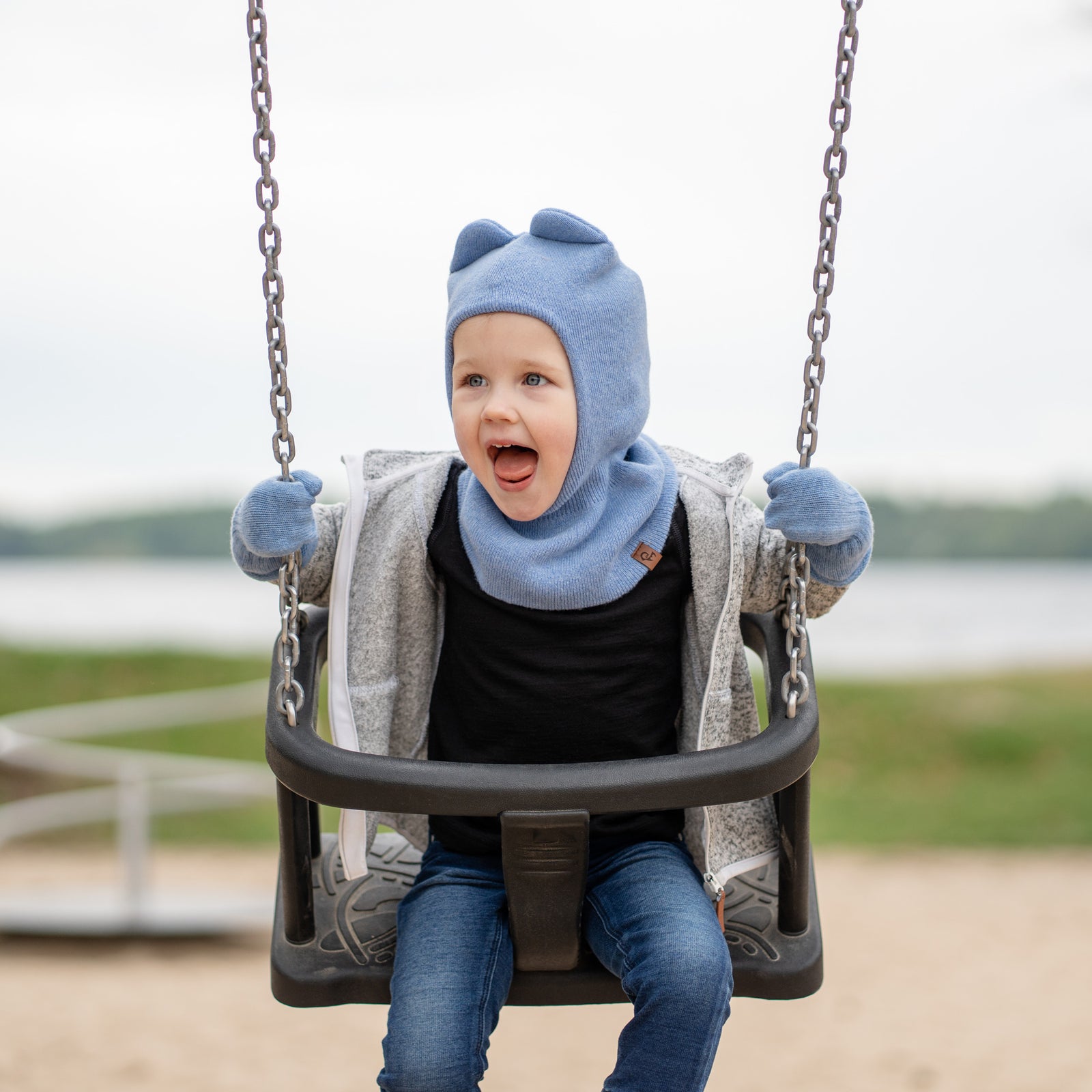 Blue knitted balaclava with attached gloves on a white background