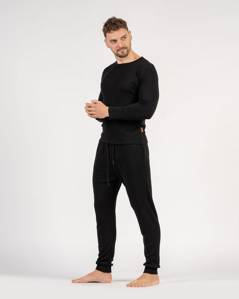 The menique men's merino wool 250gsm long sleeve top and jogger sweatpants set in black color.