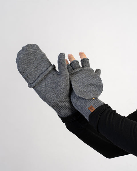 Close-up of hands showing gray convertible gloves, one with mitten flap closed and the other open to reveal fingerless design.