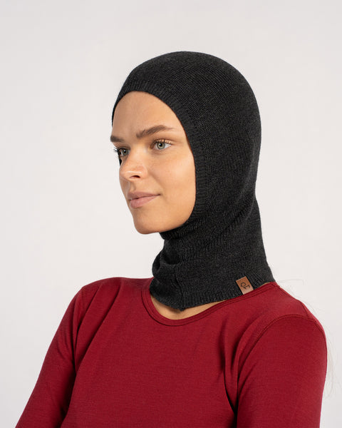 Side view of woman in a dark gray knitted Merino wool balaclava.