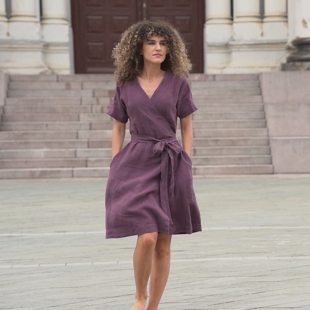 A short video of a various women wearing a menique linen wrap dress on a different locations. They smiles and moves gracefully around a palm tree or in old town.